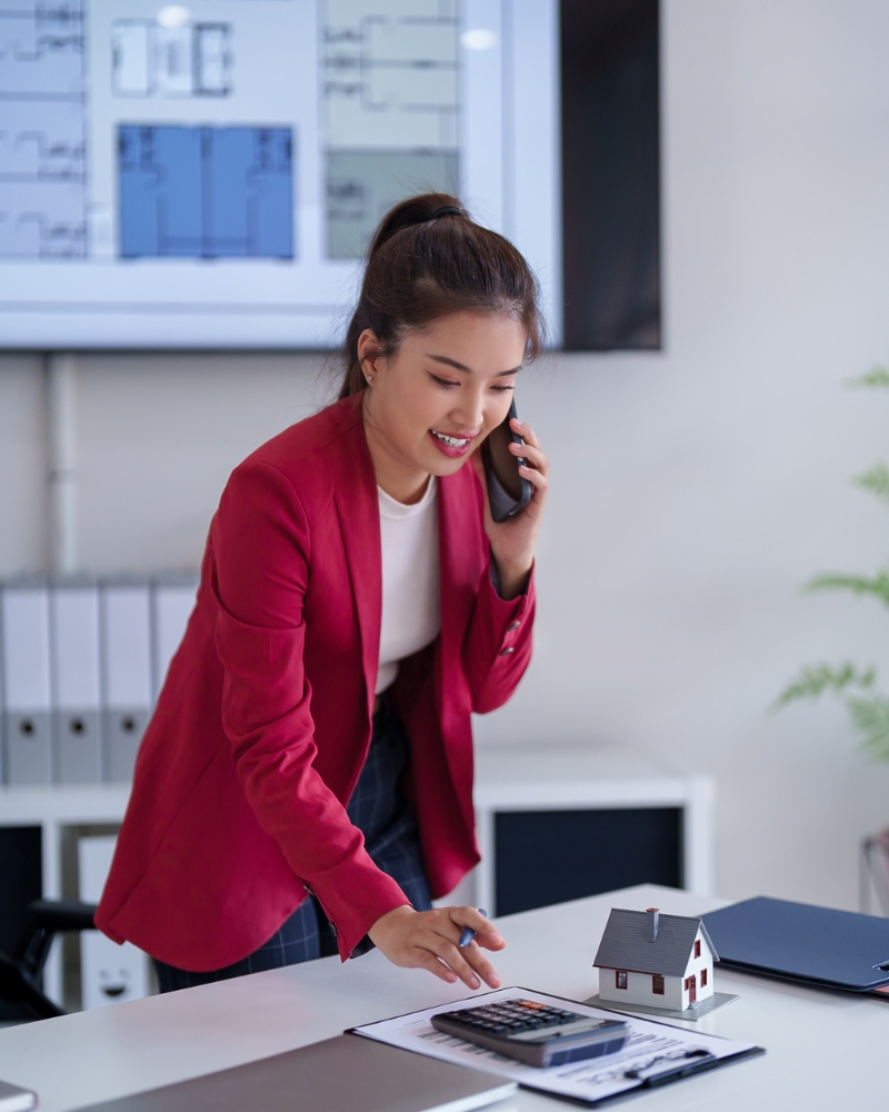 A realtor discussing a home purchase with a buyer in a modern office